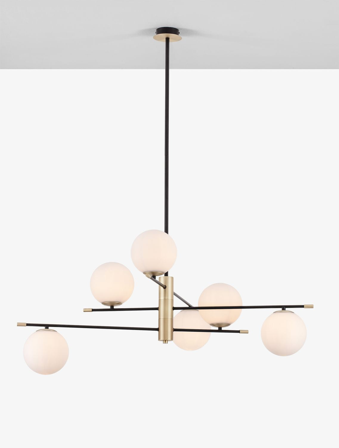Luminaire allumé, globes opalins diffusant une lumière chaude dans la pièce