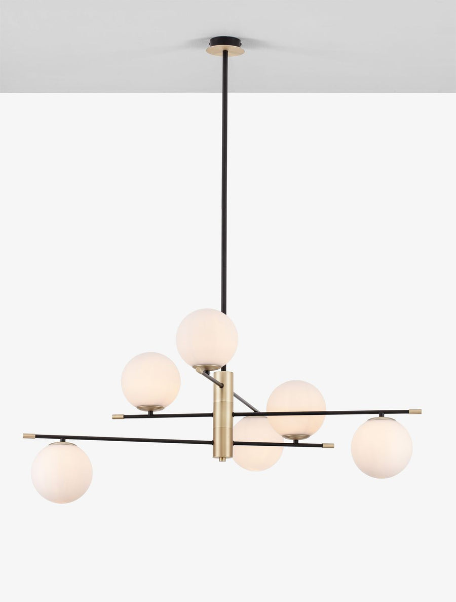 Luminaire allumé, globes opalins diffusant une lumière chaude dans la pièce