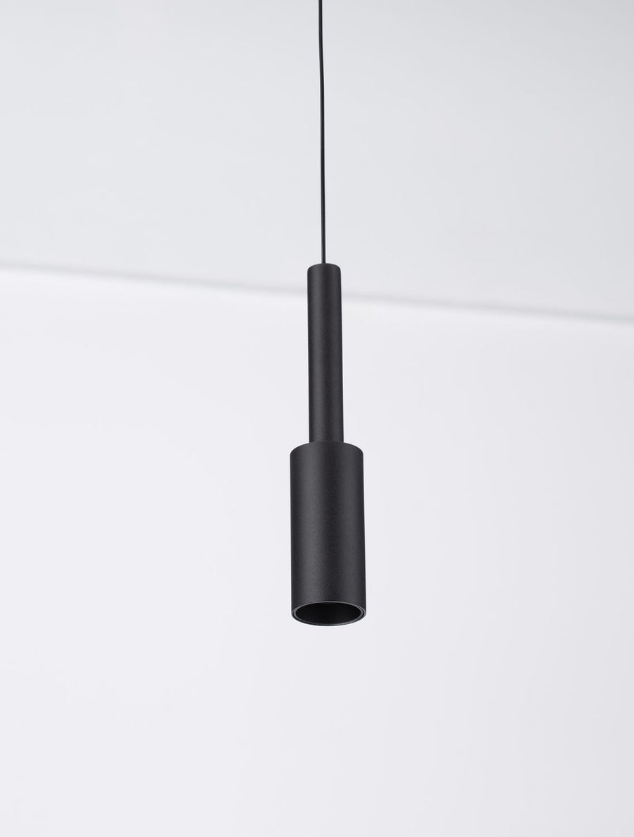 Détail du bas du luminaire montrant l'ouverture cylindrique noire et mate