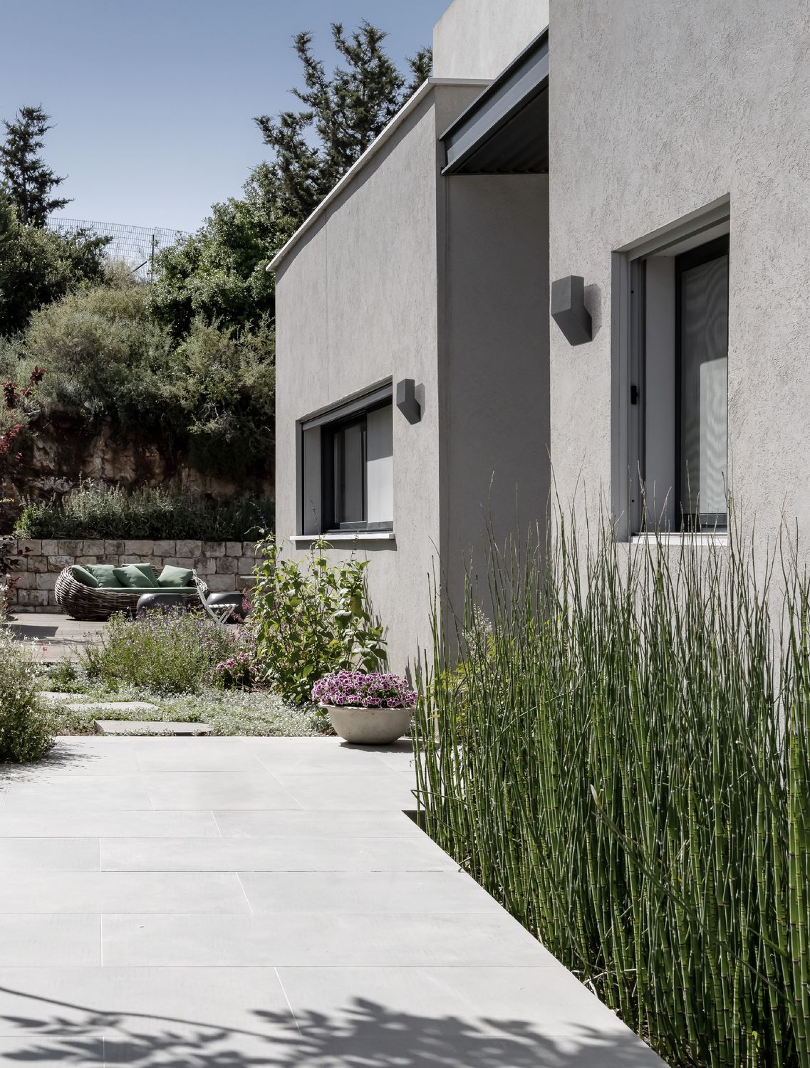 Appliques noires fixées sur la façade extérieure d'une maison moderne avec jardin
