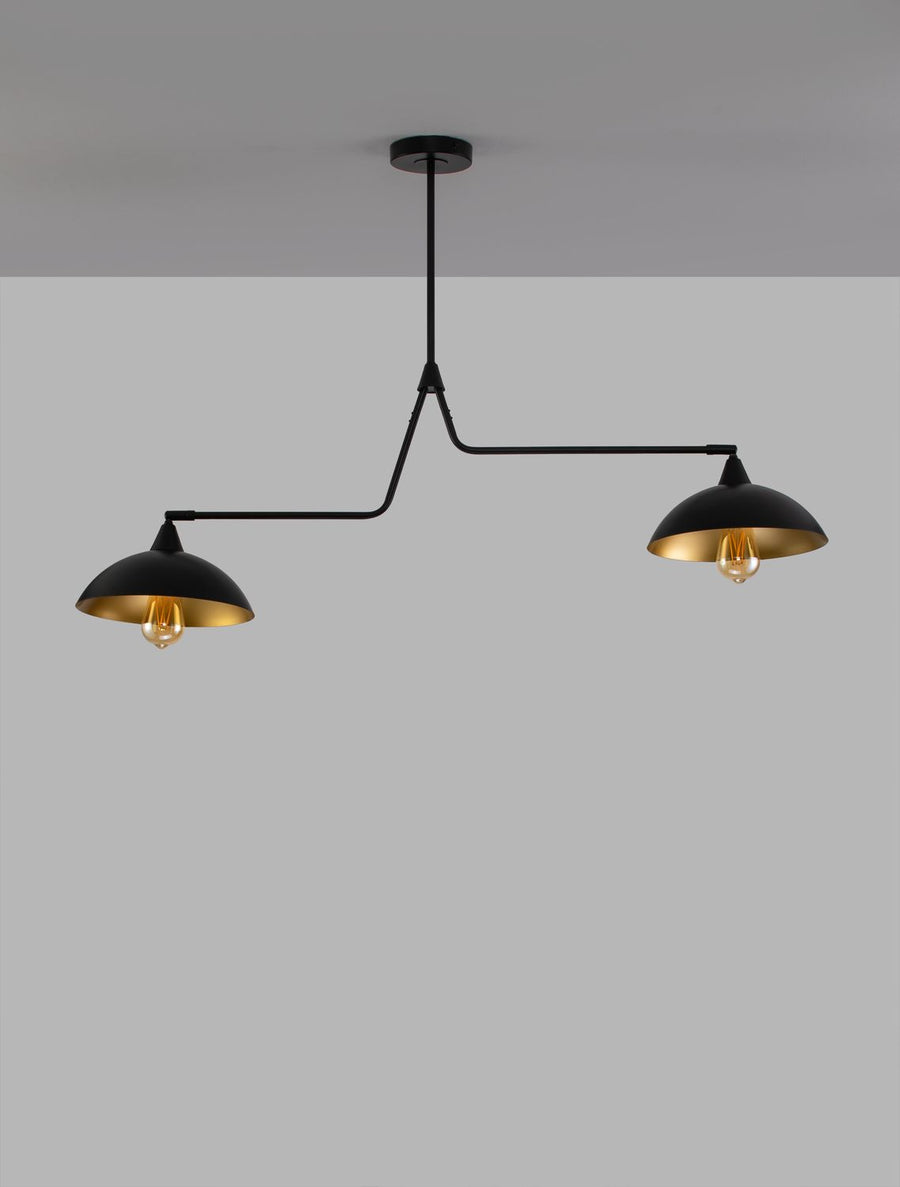 Luminaire suspendu vu de face sur fond gris, bras métalliques noirs et ampoules allumées
