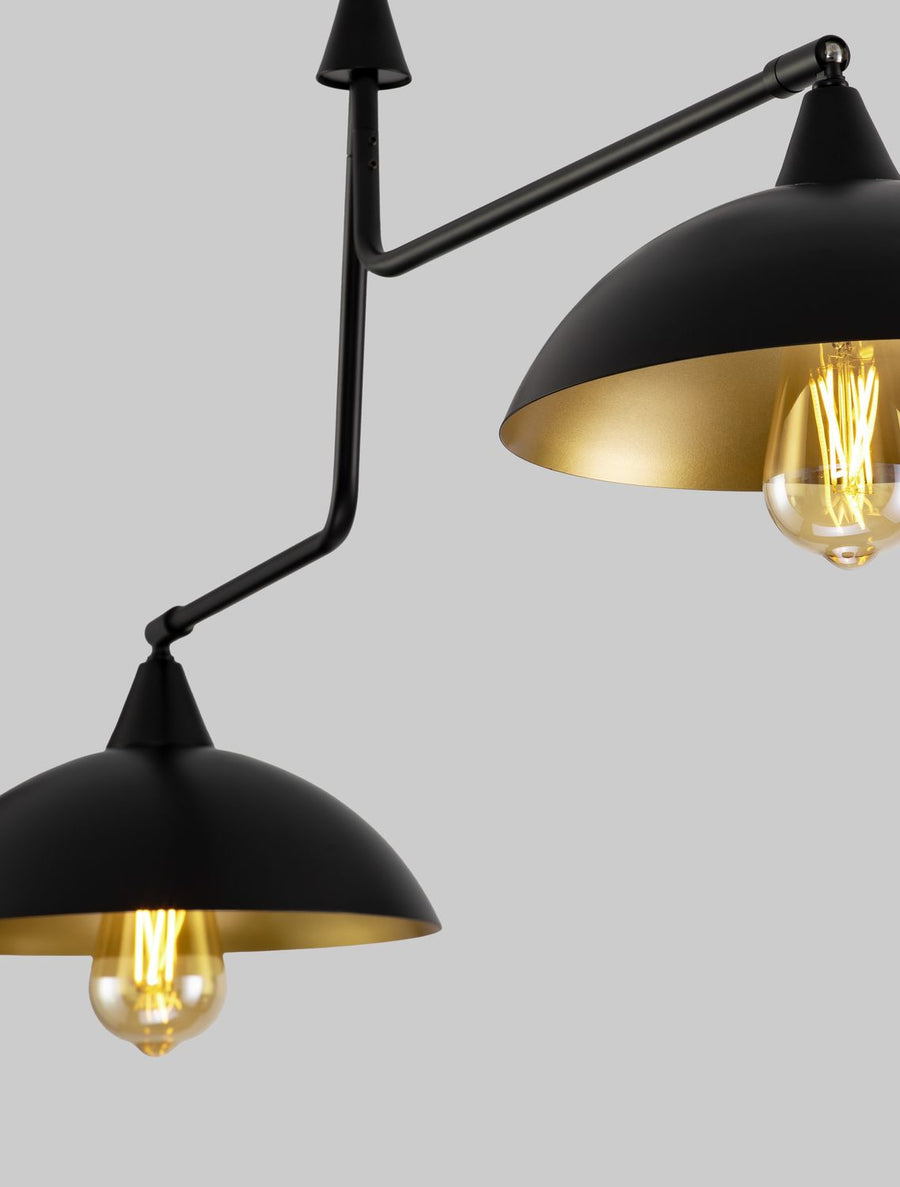 Détail rapproché des abat-jours noirs à intérieur doré et ampoules à filament