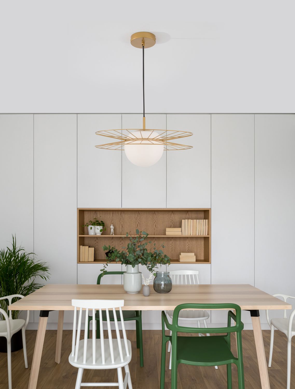 Suspension allumée au-dessus d'une table en bois dans une salle à manger claire
