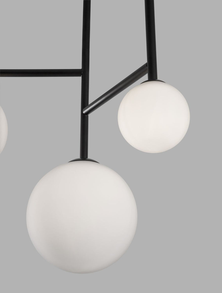 Détail rapproché des sphères en verre blanc et de l'assemblage des tiges noires