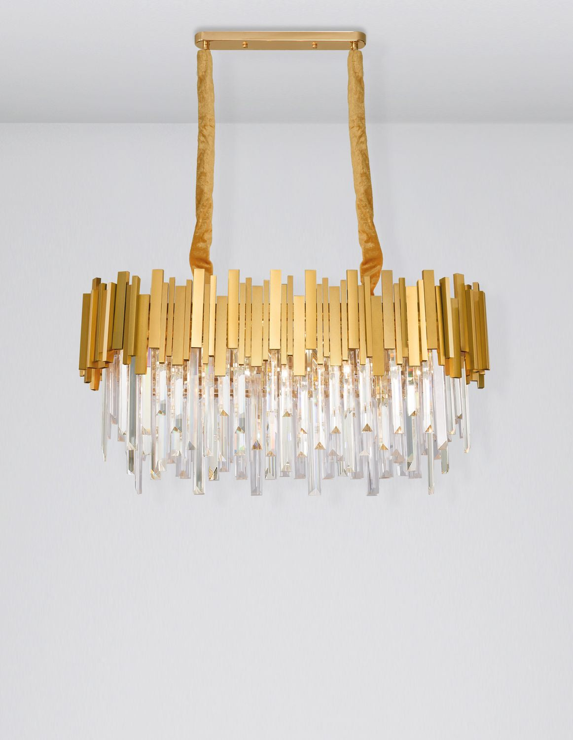 Suspension dorée vue de face, tiges de cristal taillées, fond gris clair