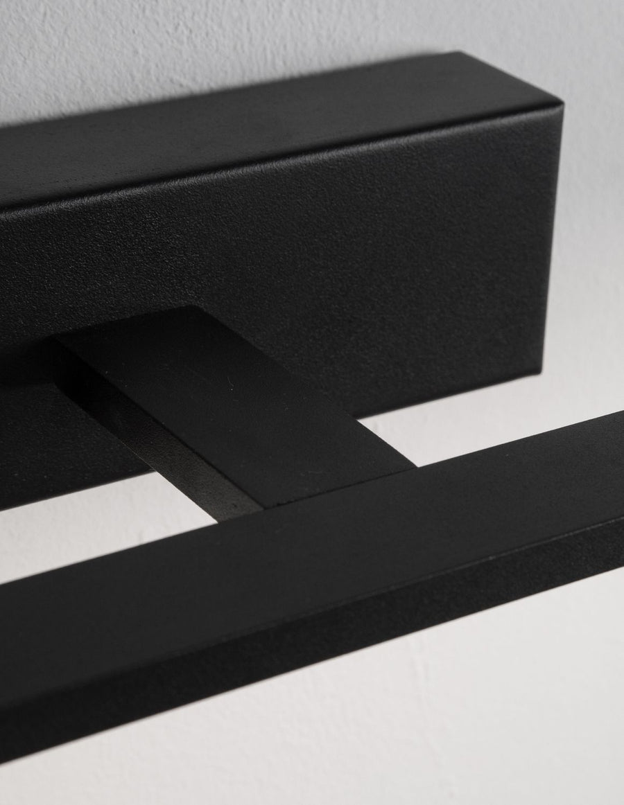 Détail rapproché de la finition noire mate et de la jonction entre barre et socle
