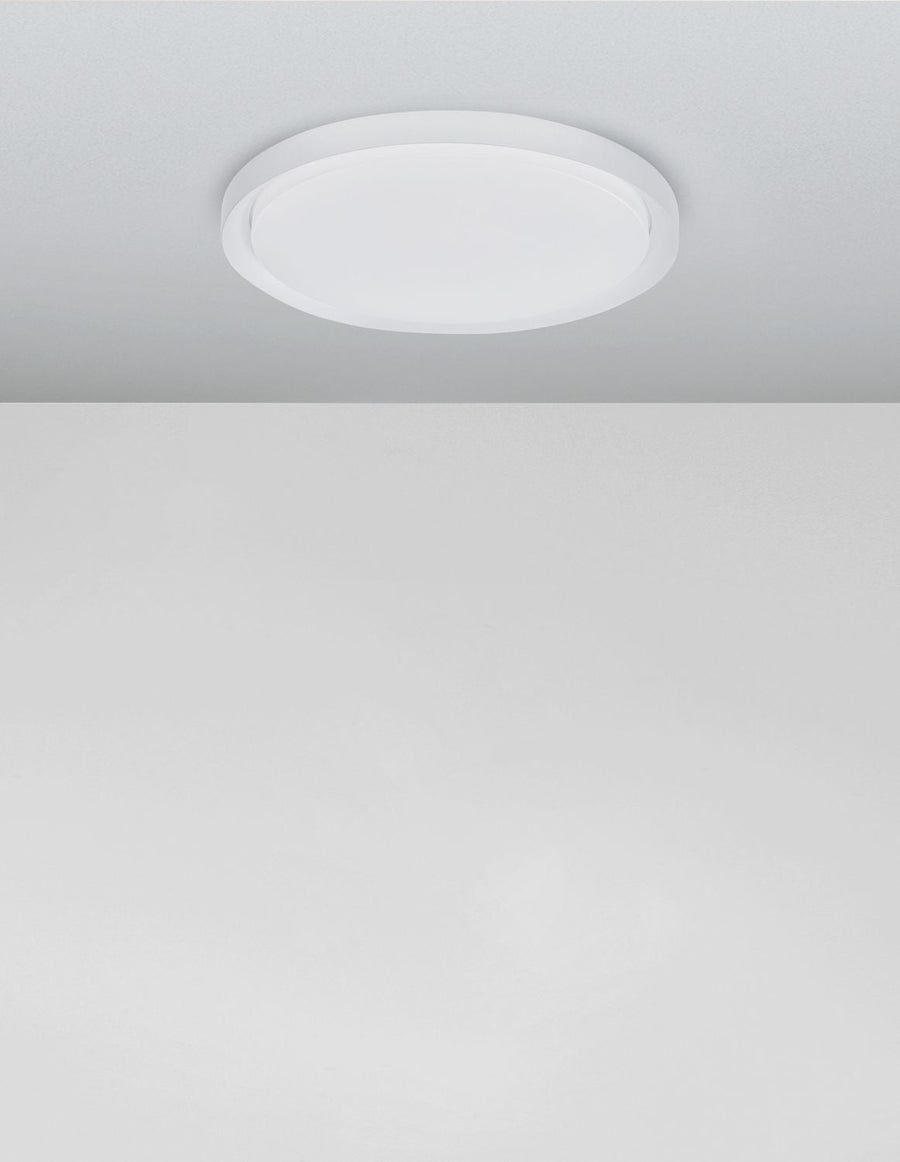 Plafonnier blanc fixé au plafond dans une pièce claire et épurée