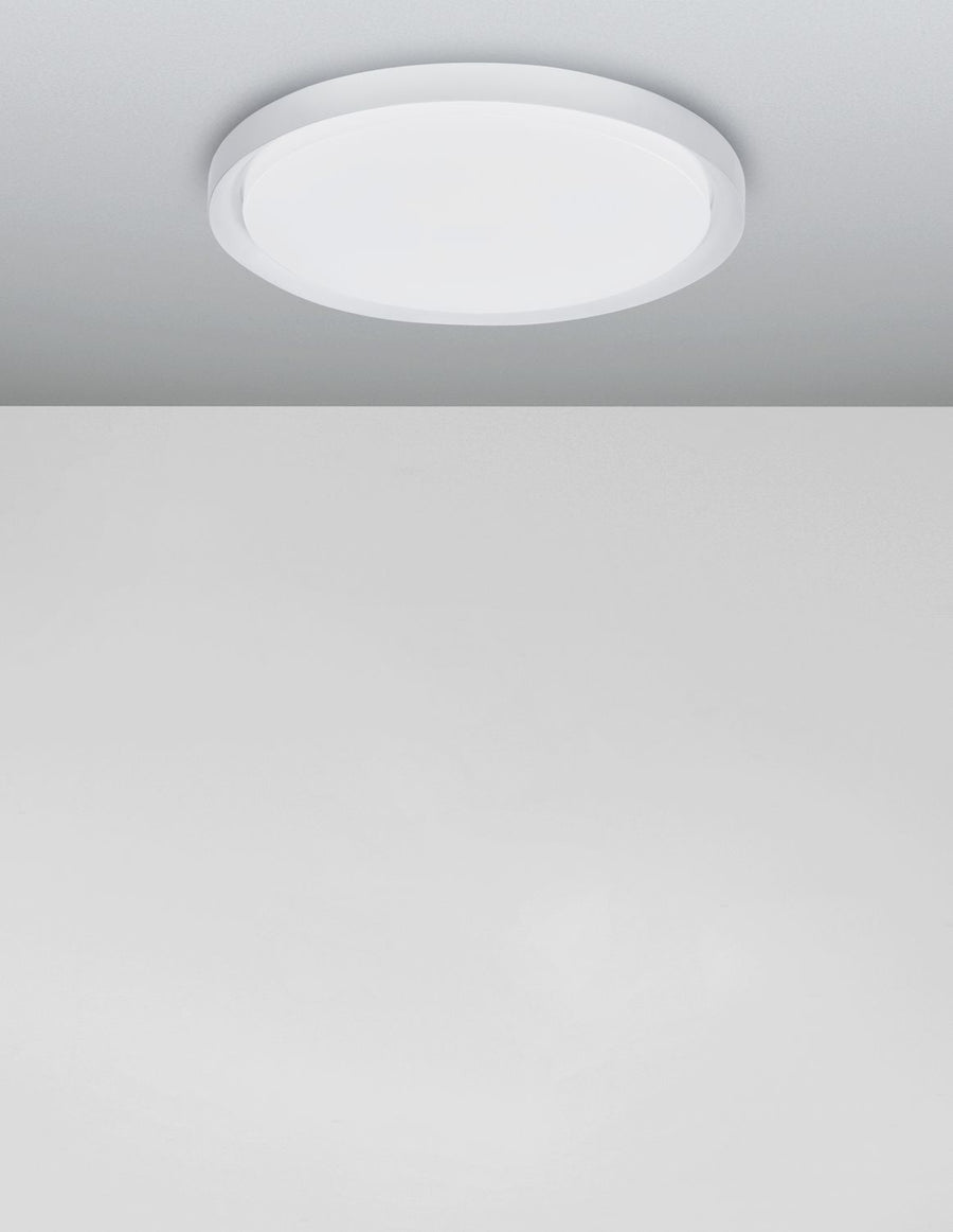 Plafonnier allumé au plafond, halo lumineux diffus dans une pièce grise