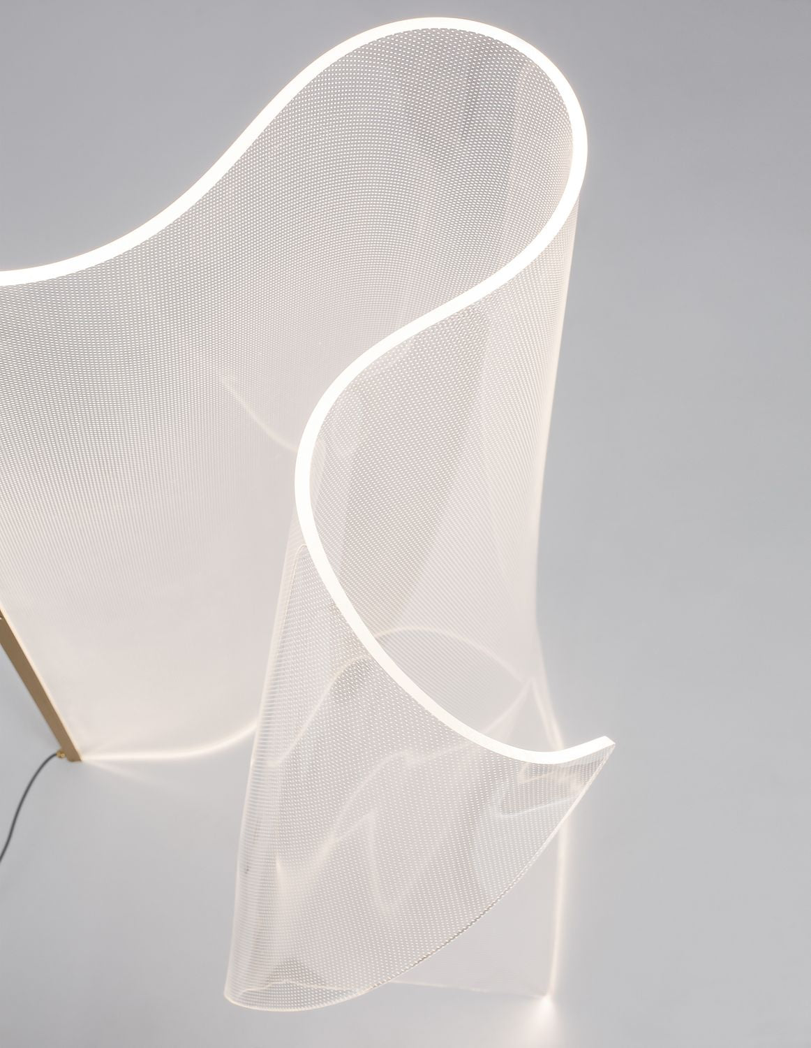 Vue rapprochée du panneau ondulé blanc et de sa bordure lumineuse, tige dorée à gauche.