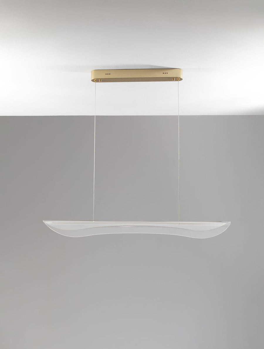 Vue de trois quarts du luminaire allumé sous un plafond gris