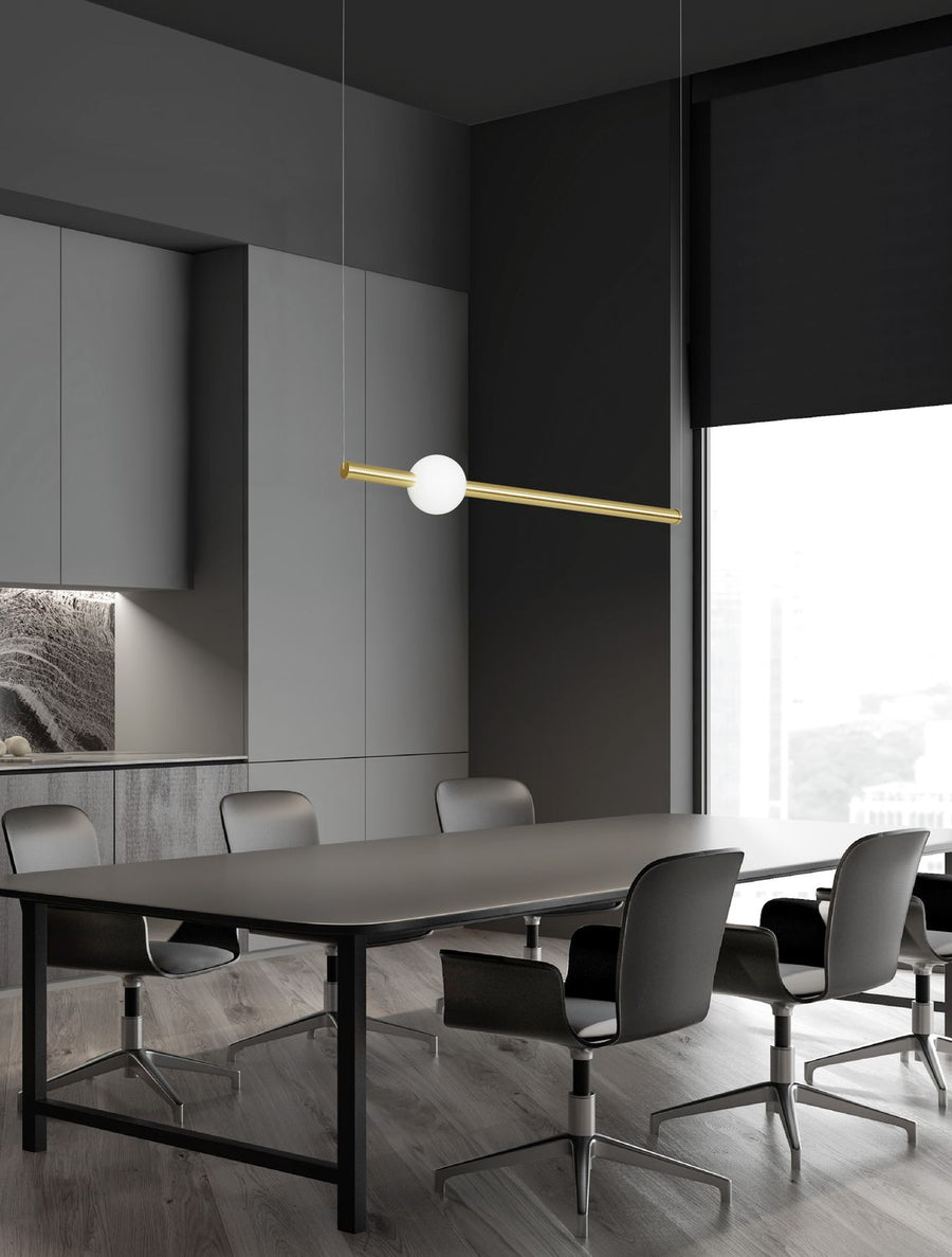 Suspension dorée installée au-dessus d'une grande table dans un intérieur gris contemporain