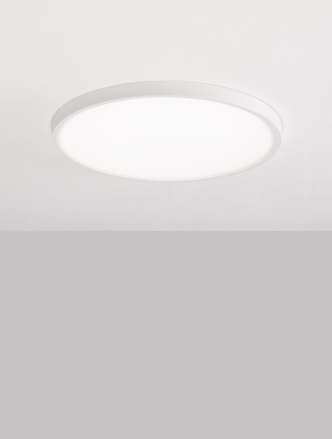 Plafonnier rond blanc allumé diffusant une lumière douce et homogène