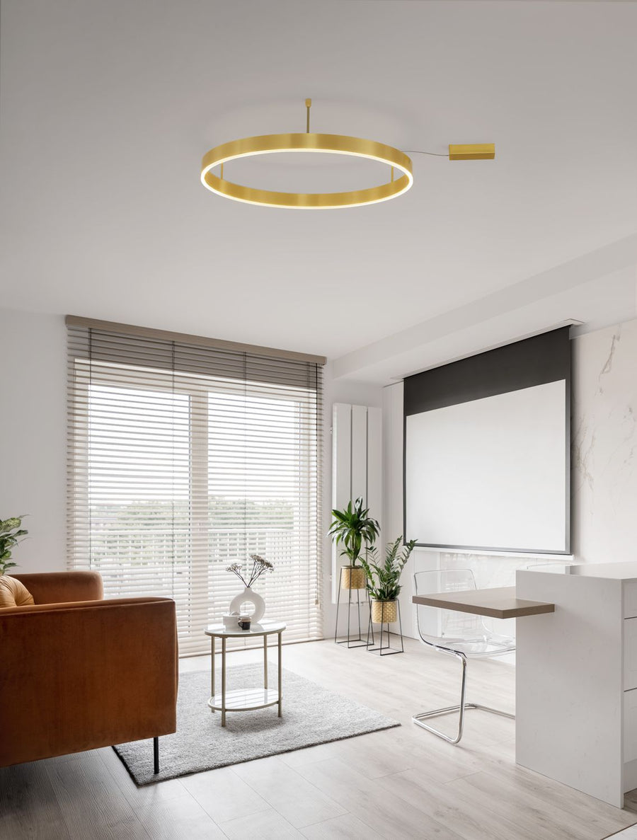 Salon contemporain avec canapé en cuir et plafonnier anneau doré allumé au plafond