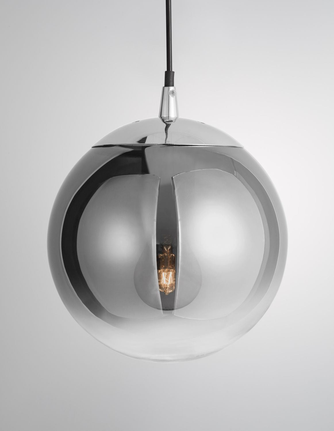 Suspension sphérique en verre chromé, ampoule allumée visible au centre du réflecteur