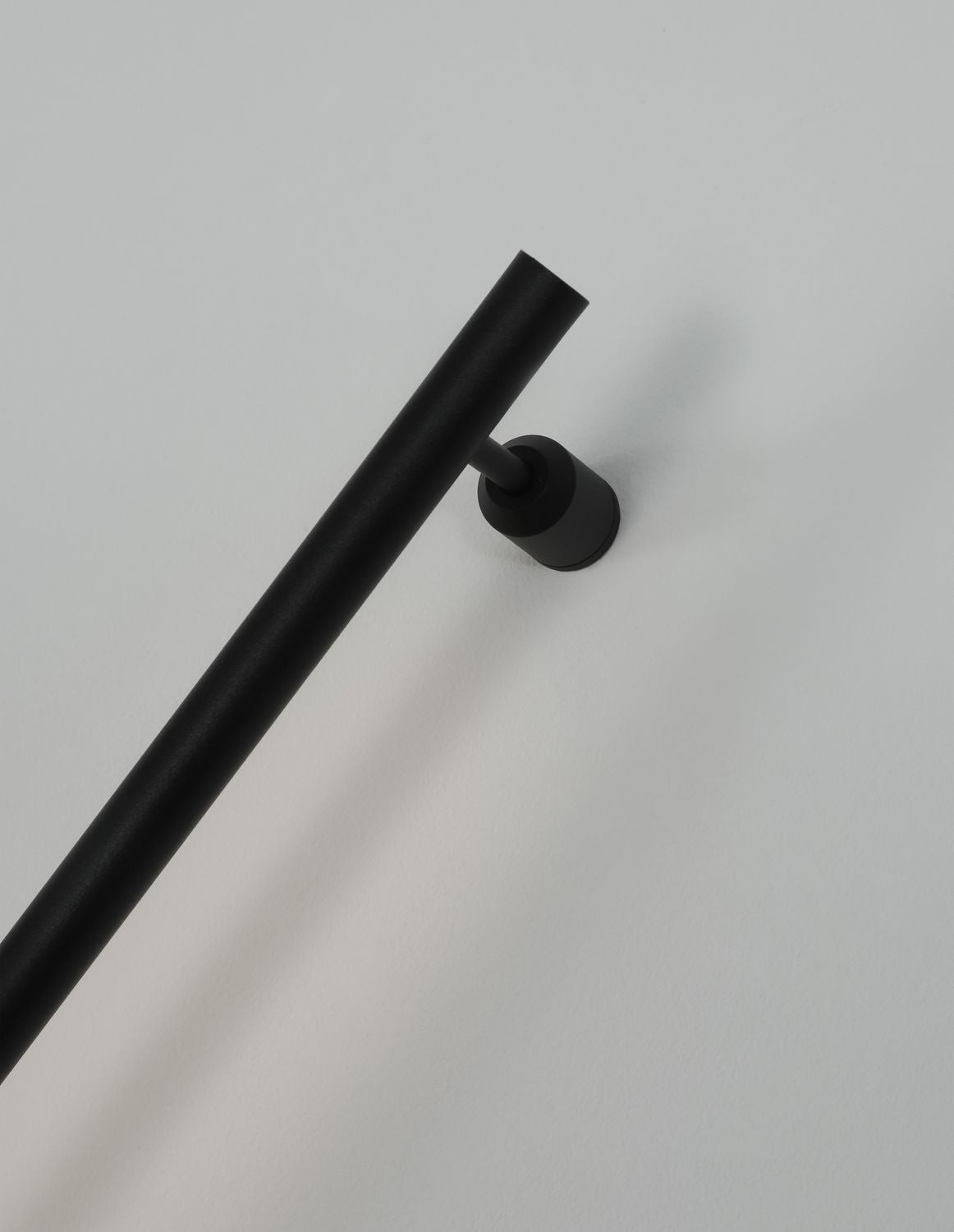 Détail de la fixation murale cylindrique et du bras articulé noir