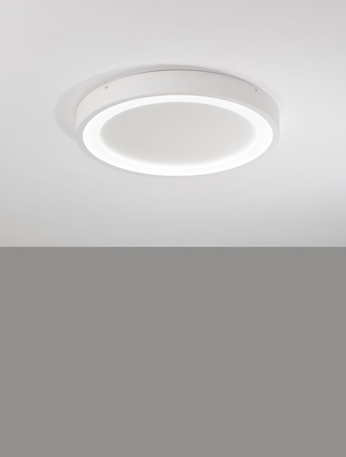 Plafonnier rond blanc allumé, fixé au plafond, vu de face en intérieur contemporain
