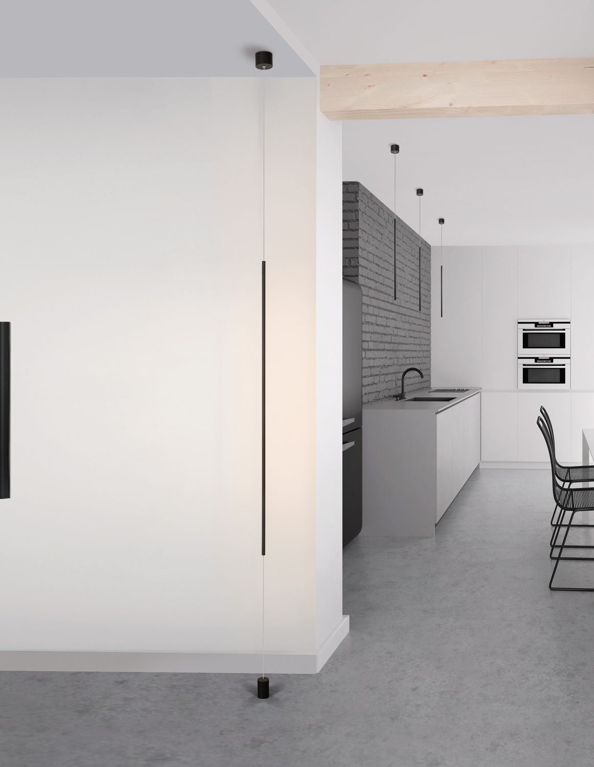 Mise en ambiance : suspension noire verticale dans une cuisine blanche avec îlot central