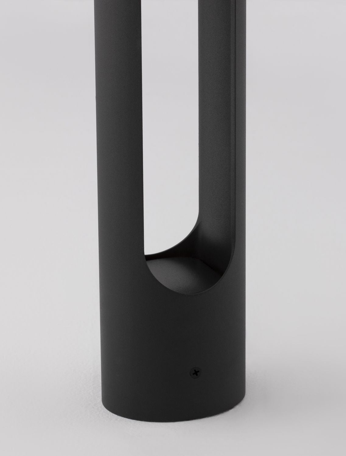 Détail du bas de la borne, révélation du socle et vis de fixation apparente.