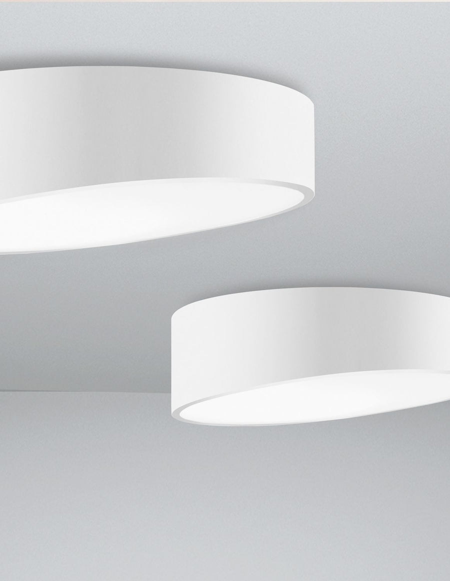 Deux plafonniers blancs de tailles différentes fixés au plafond, côte à côte