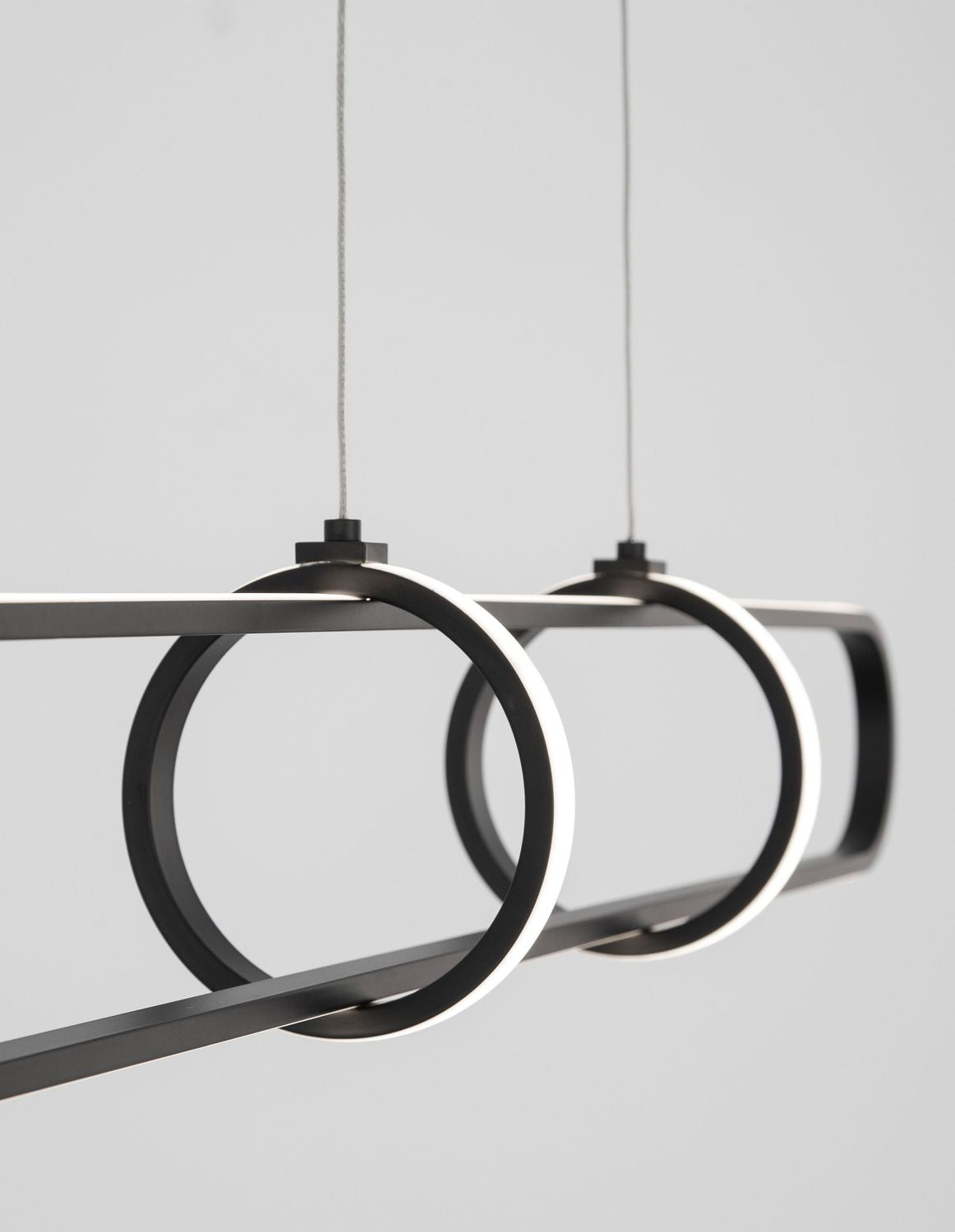 Détail de profil des deux anneaux lumineux posés sur la structure horizontale noire mate