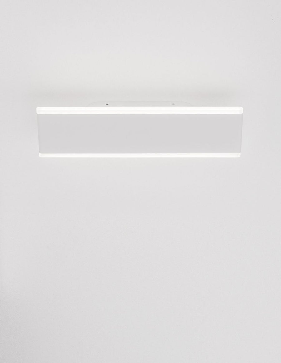 Applique murale blanche fixée au mur, éclairant vers le haut et vers le bas.