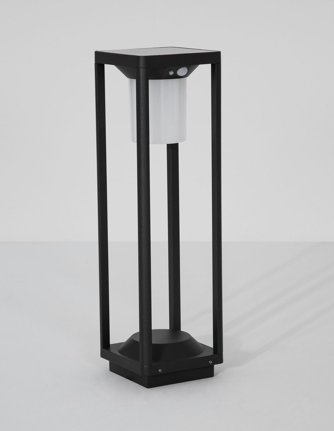 Face avant en studio : structure noire ajourée et cylindre lumineux opalin activé.