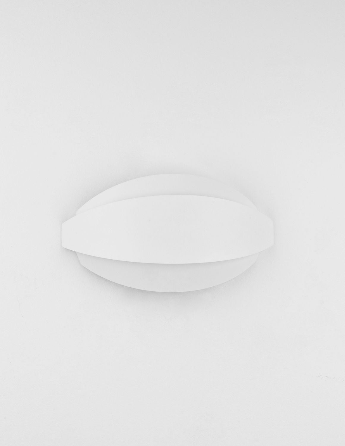 Applique blanche légèrement inclinée, silhouette ovale épurée sur fond clair