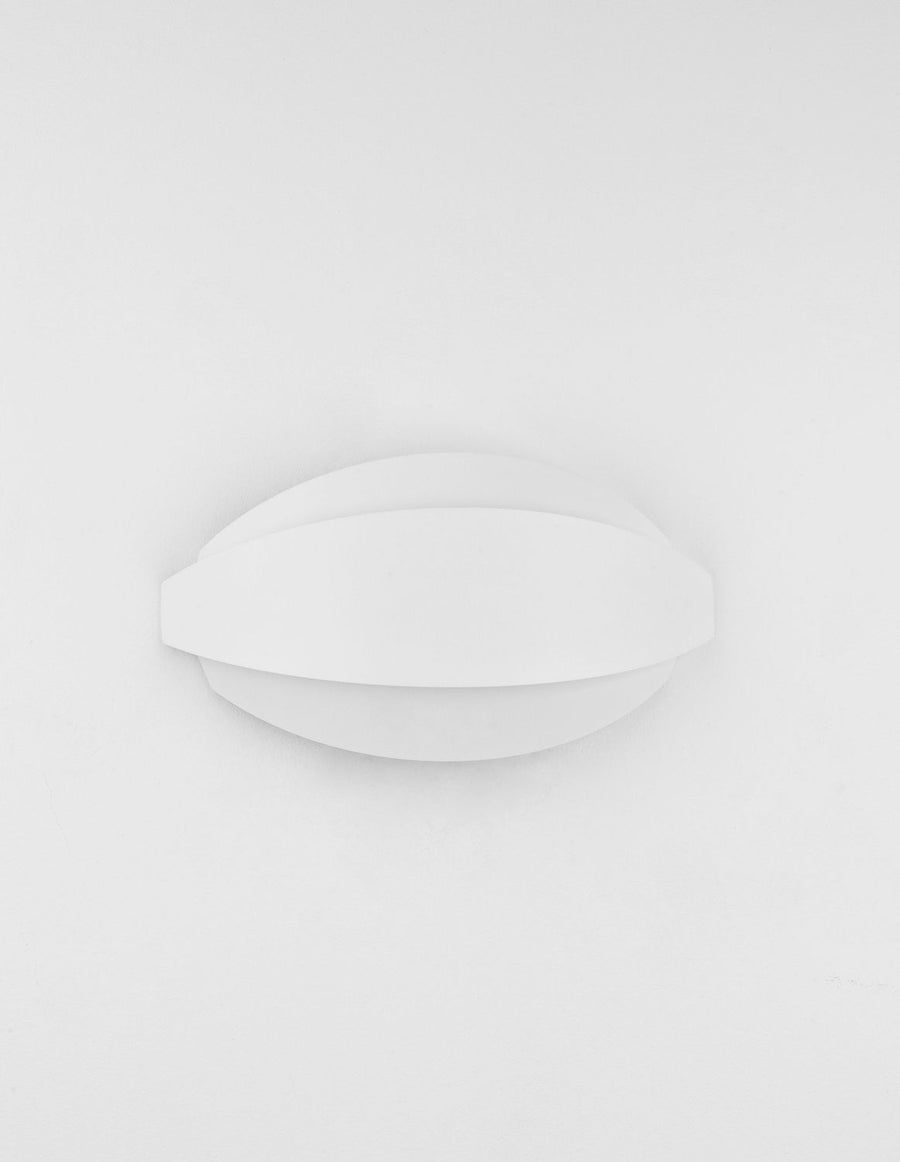 Applique blanche légèrement inclinée, silhouette ovale épurée sur fond clair