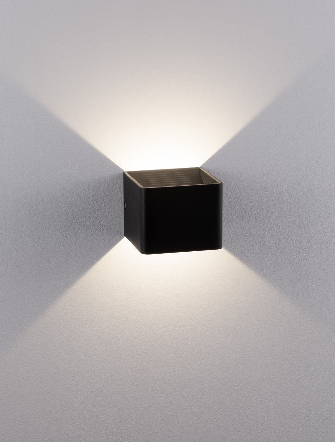 Vue rapprochée du luminaire éclairé, halo chaud débordant au-dessus et en dessous