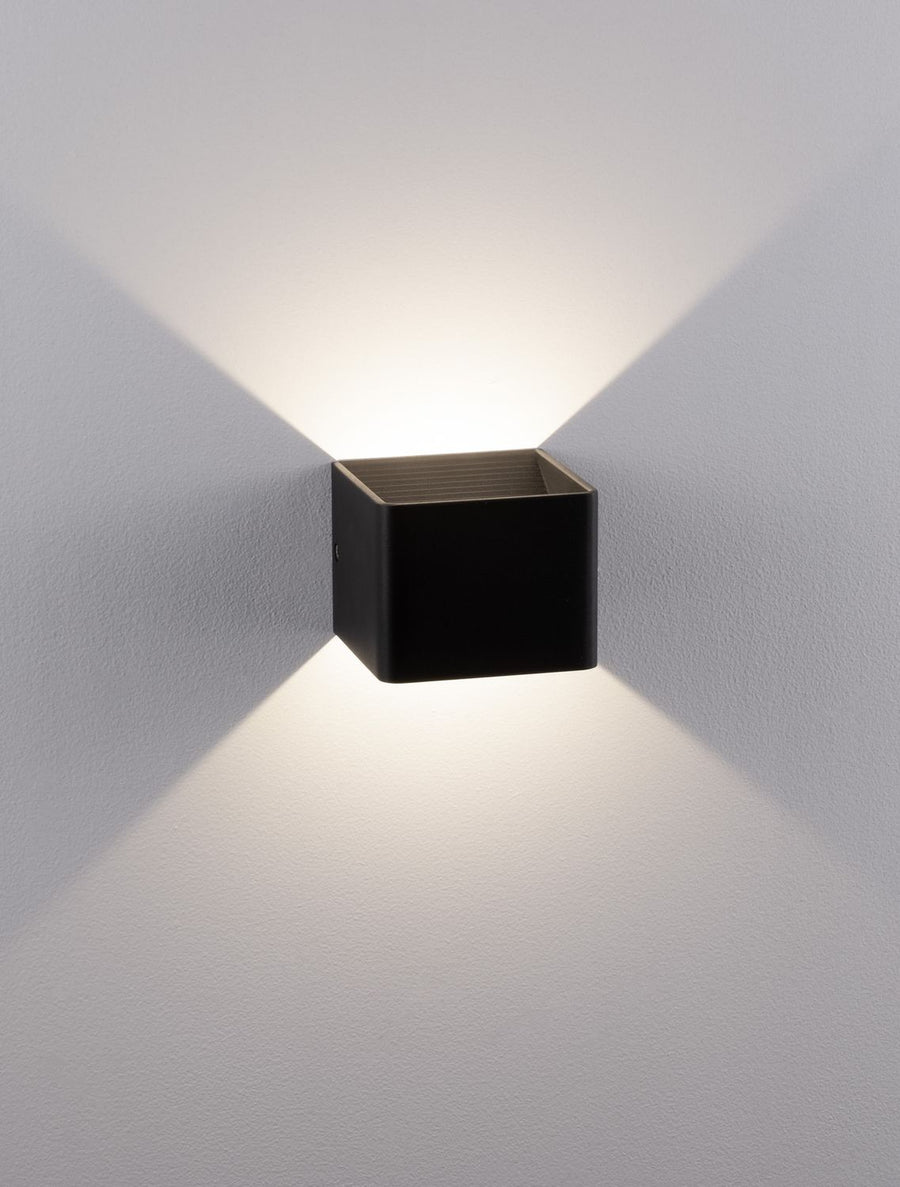 Vue rapprochée du luminaire éclairé, halo chaud débordant au-dessus et en dessous