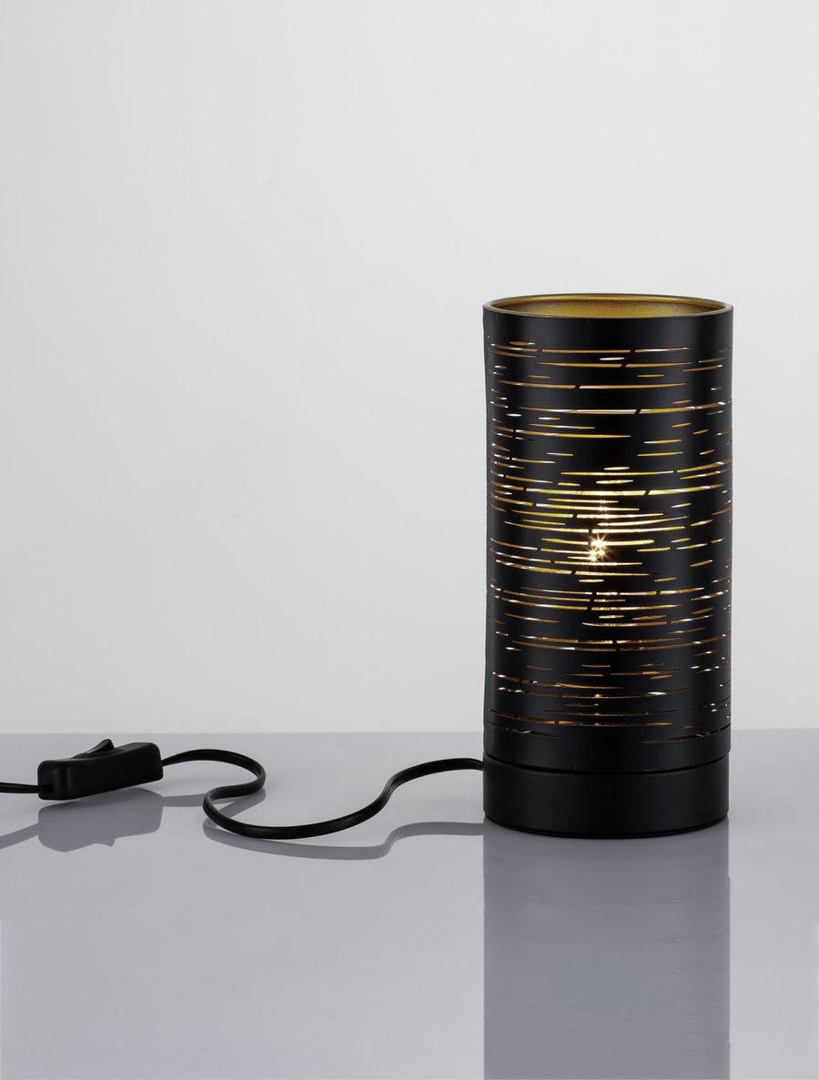 Lampe cylindrique noire posée sur une table, câble et interrupteur visibles