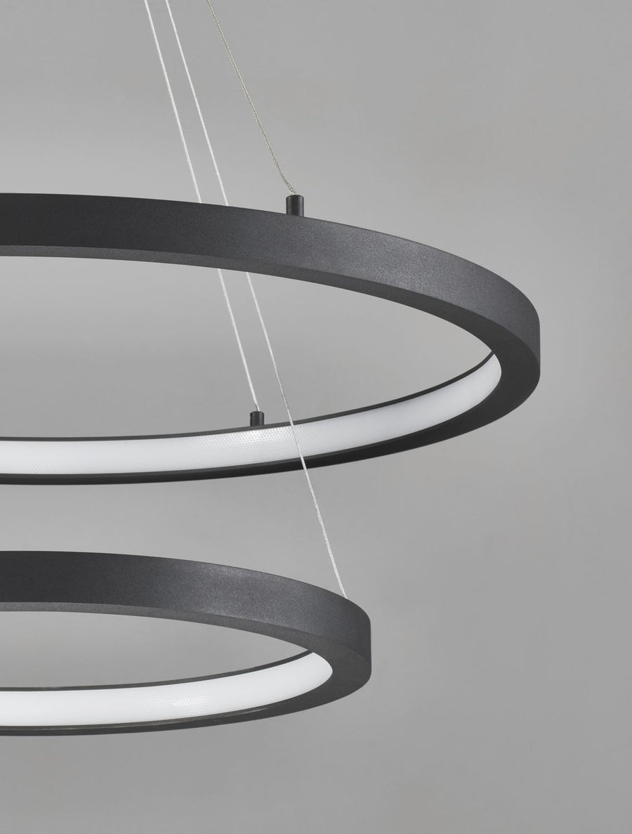 Gros plan sur deux anneaux noirs suspendus et leur diffuseur LED blanc