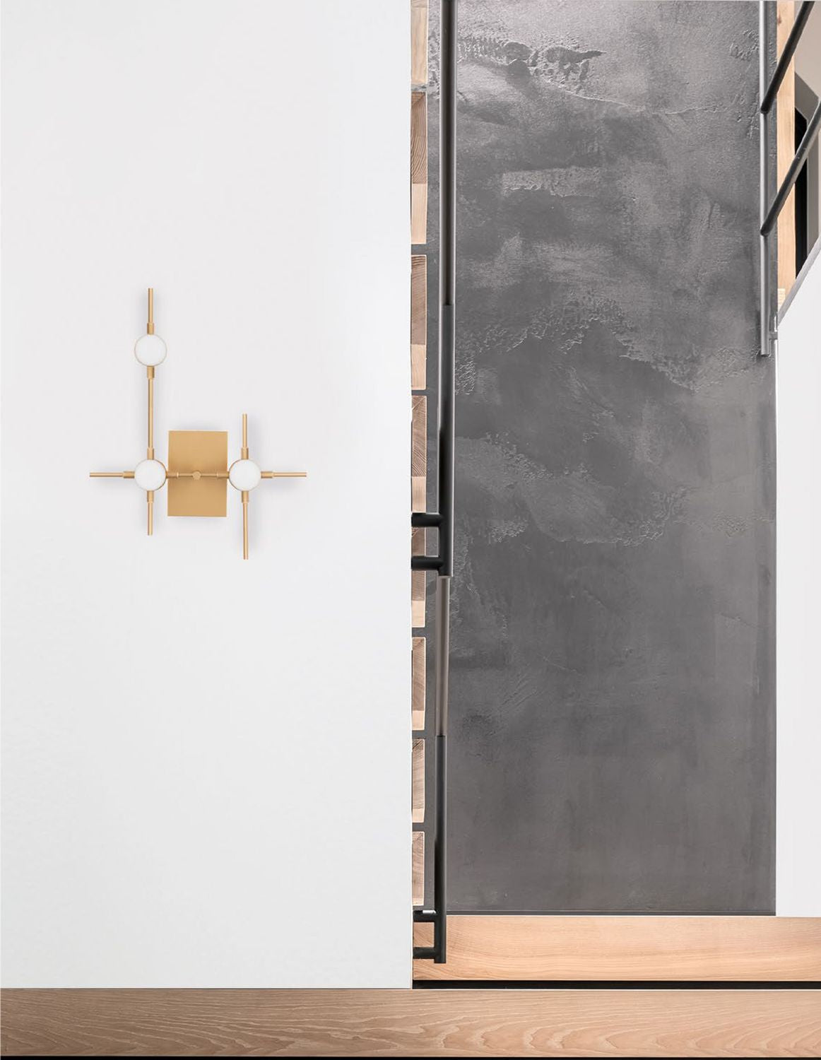 Applique murale dorée fixée sur mur blanc dans un intérieur béton et bois