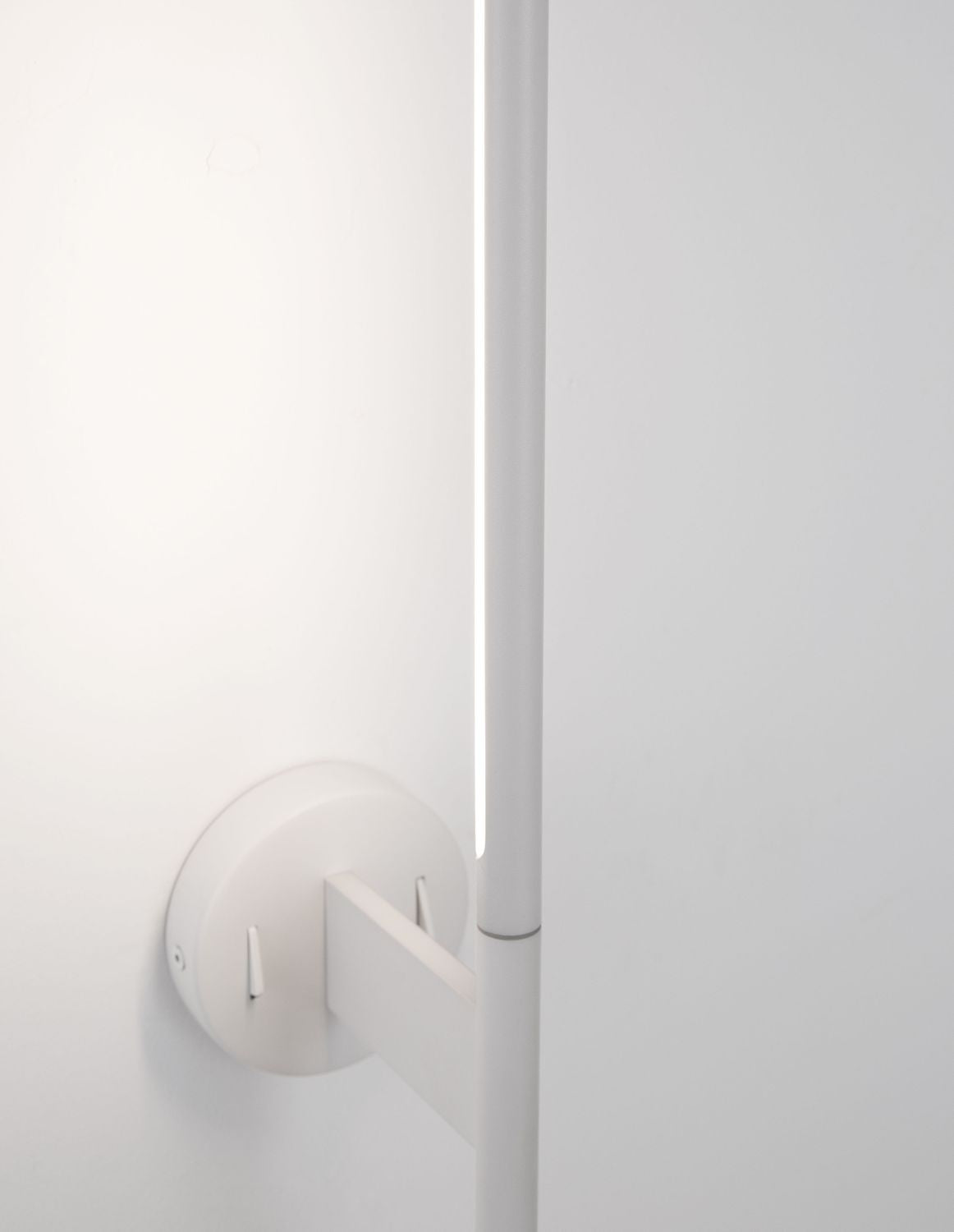 Détail du socle circulaire blanc et de la fixation murale avec vis apparentes.