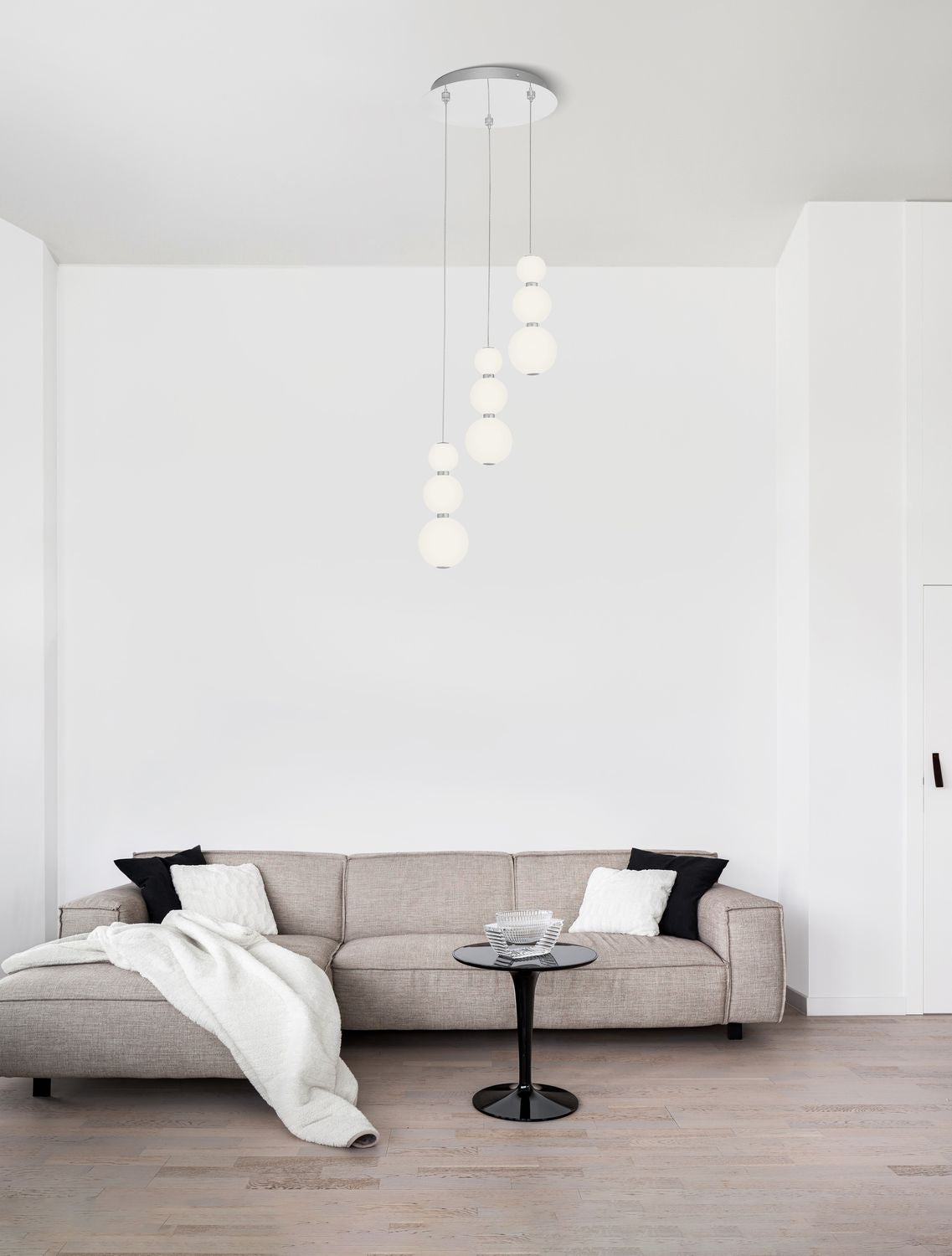 Suspension à trois câbles avec globes de verre blanc dans un salon contemporain