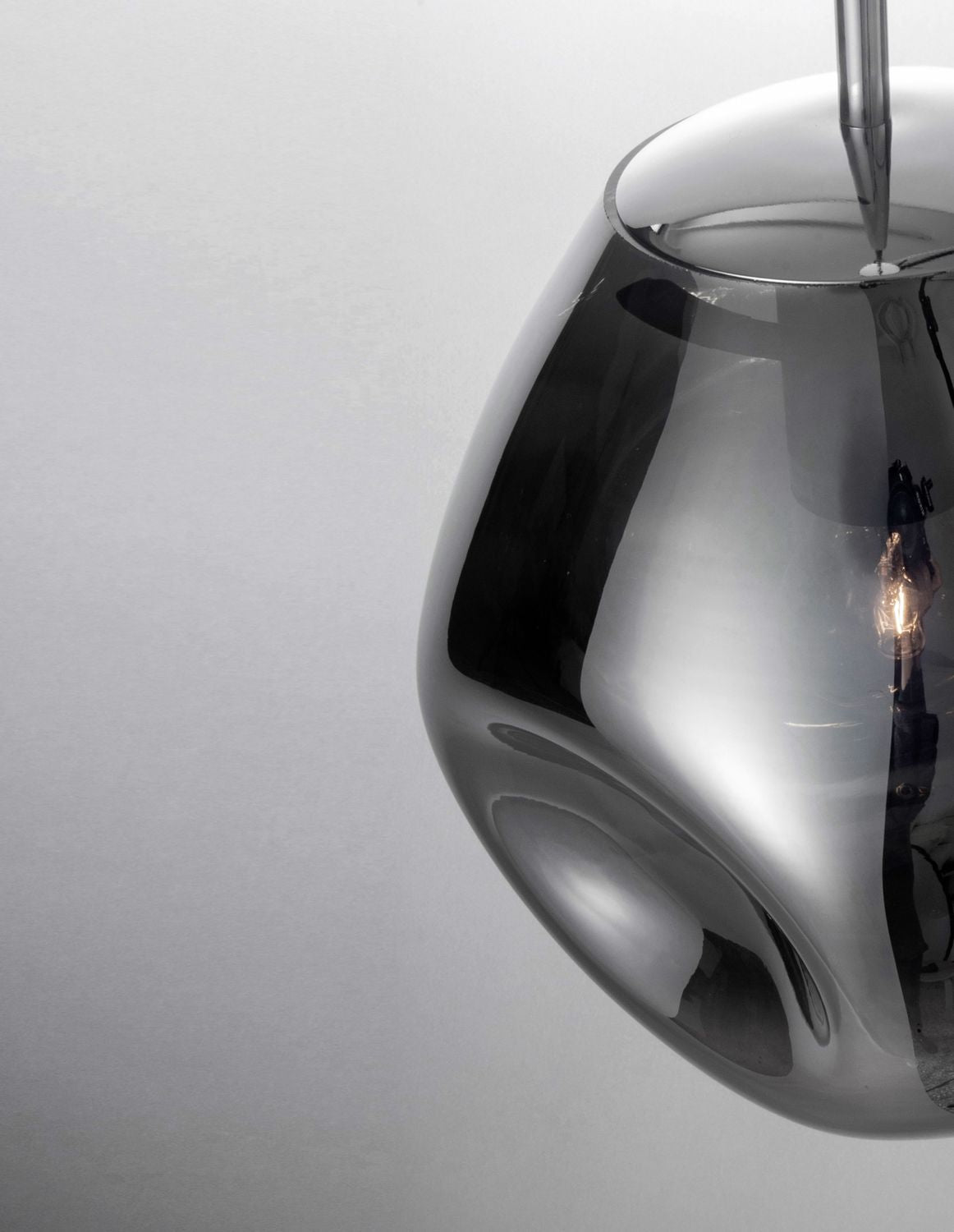 Détail du globe en verre chromé avec reflets et douille visible à l'intérieur.