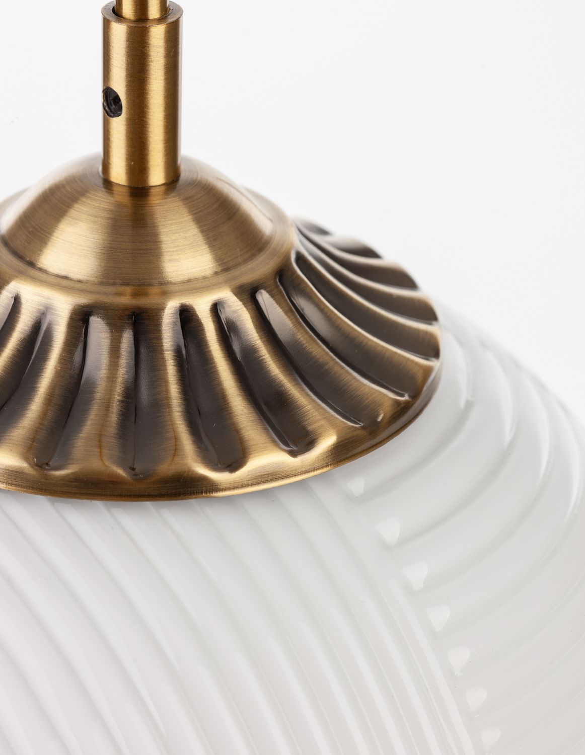 Détail du collier en laiton godronné posé sur le verre strié