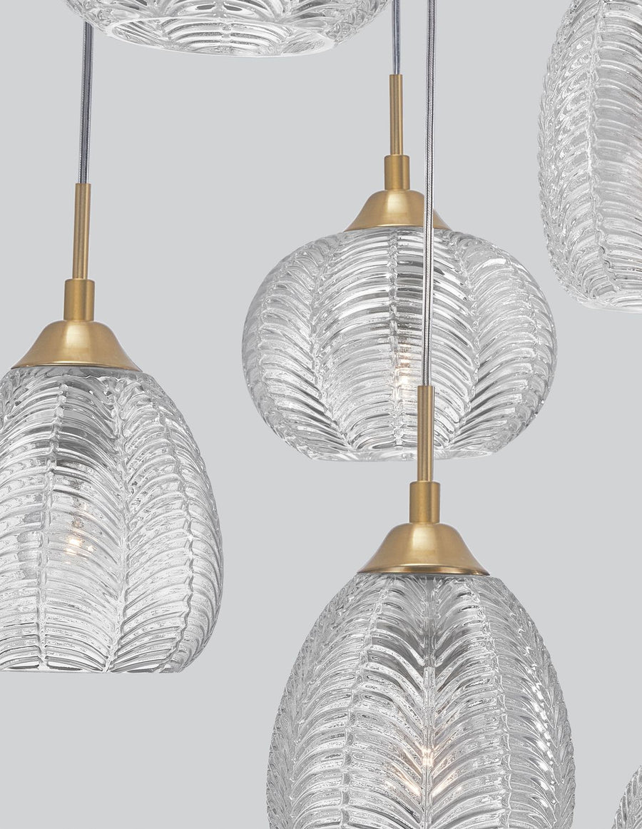 Détail rapproché de trois globes en verre strié et de leurs fixations dorées