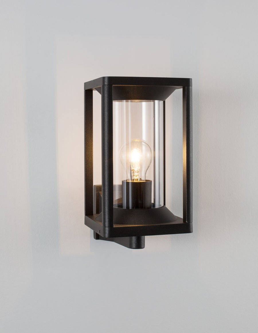 Produit de face sur fond gris clair, applique rectangulaire noire, ampoule allumée et verre interne.