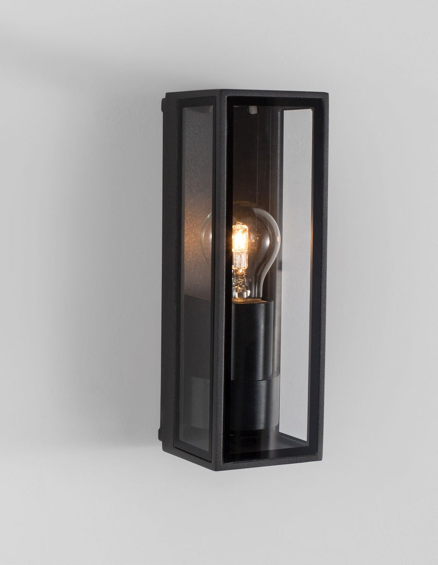 Vue en perspective du luminaire allumé, montrant les vitres latérales et le socle