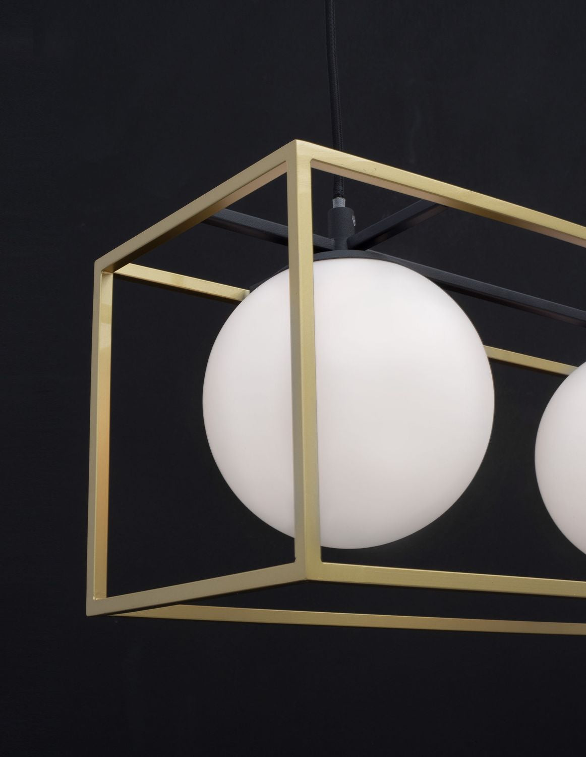 Gros plan sur un globe blanc et le cadre doré rectangulaire du luminaire