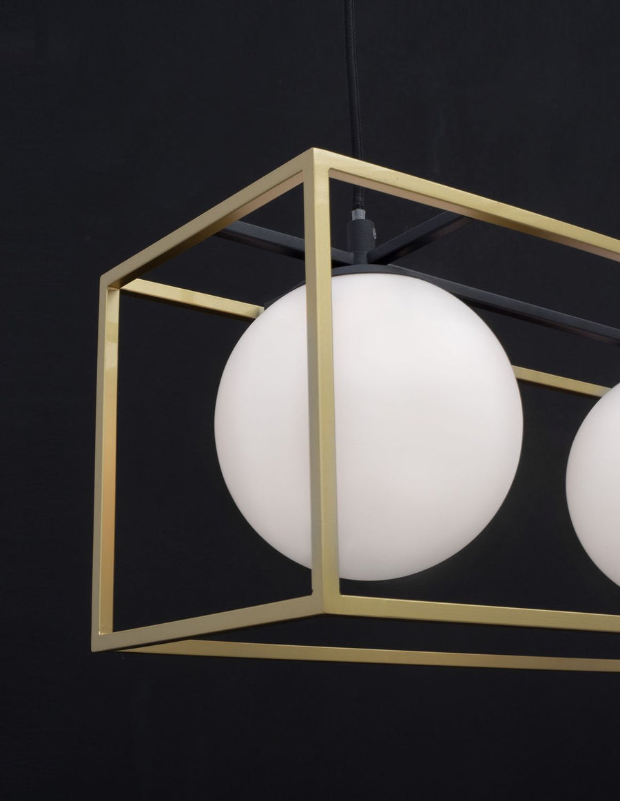 Gros plan sur un globe blanc et le cadre doré rectangulaire du luminaire