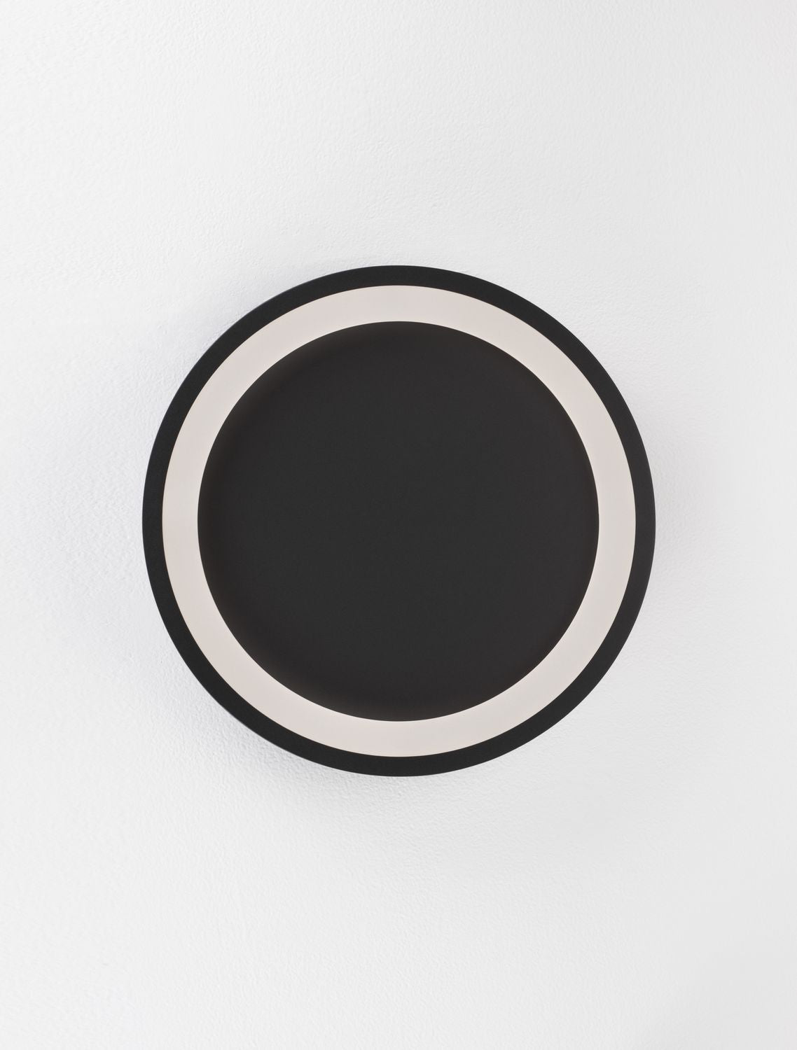 Vue de face du luminaire circulaire noir sur fond blanc, anneau lumineux