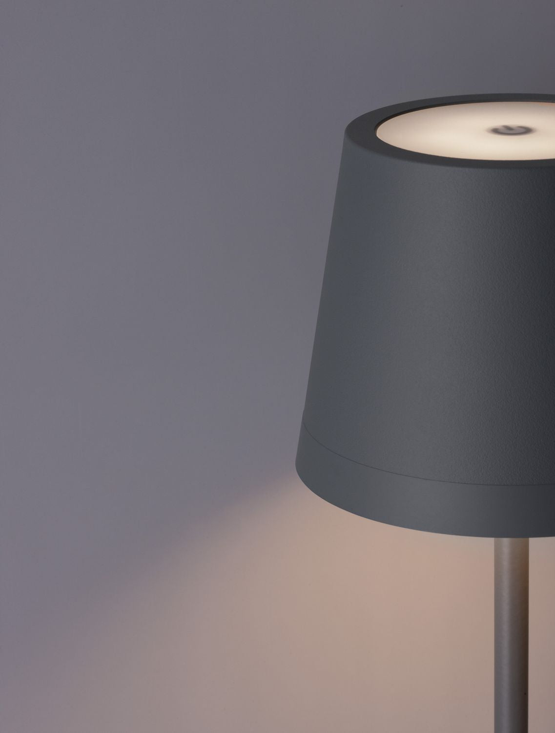 Gros plan du dessus de l'abat-jour avec interrupteur tactile et lumière chaude.