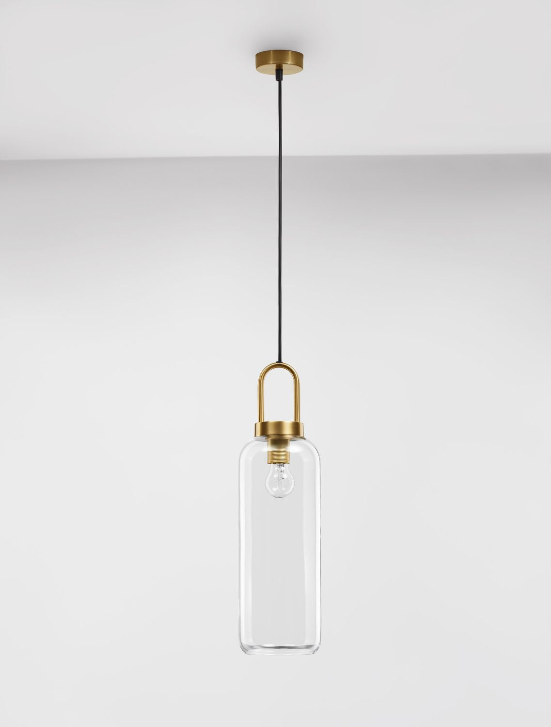 Suspension en verre transparent suspendue devant un mur blanc, plan large