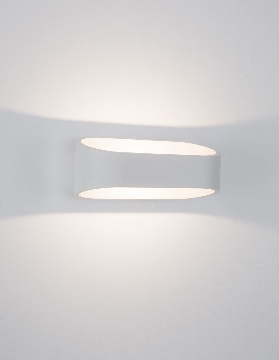 Diffuseur allumé projetant deux halos de lumière douce sur le mur blanc