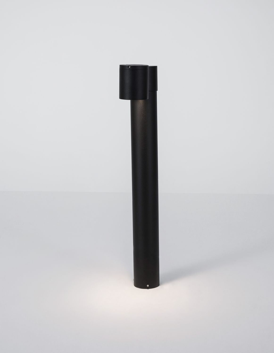 Produit de face sur fond clair, projecteur décalé et allumé au sol.
