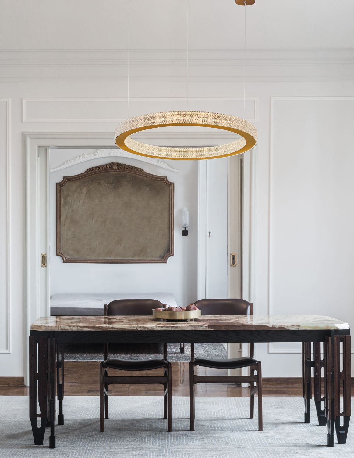 Suspension dorée en anneau installée au-dessus d'une table à manger en marbre