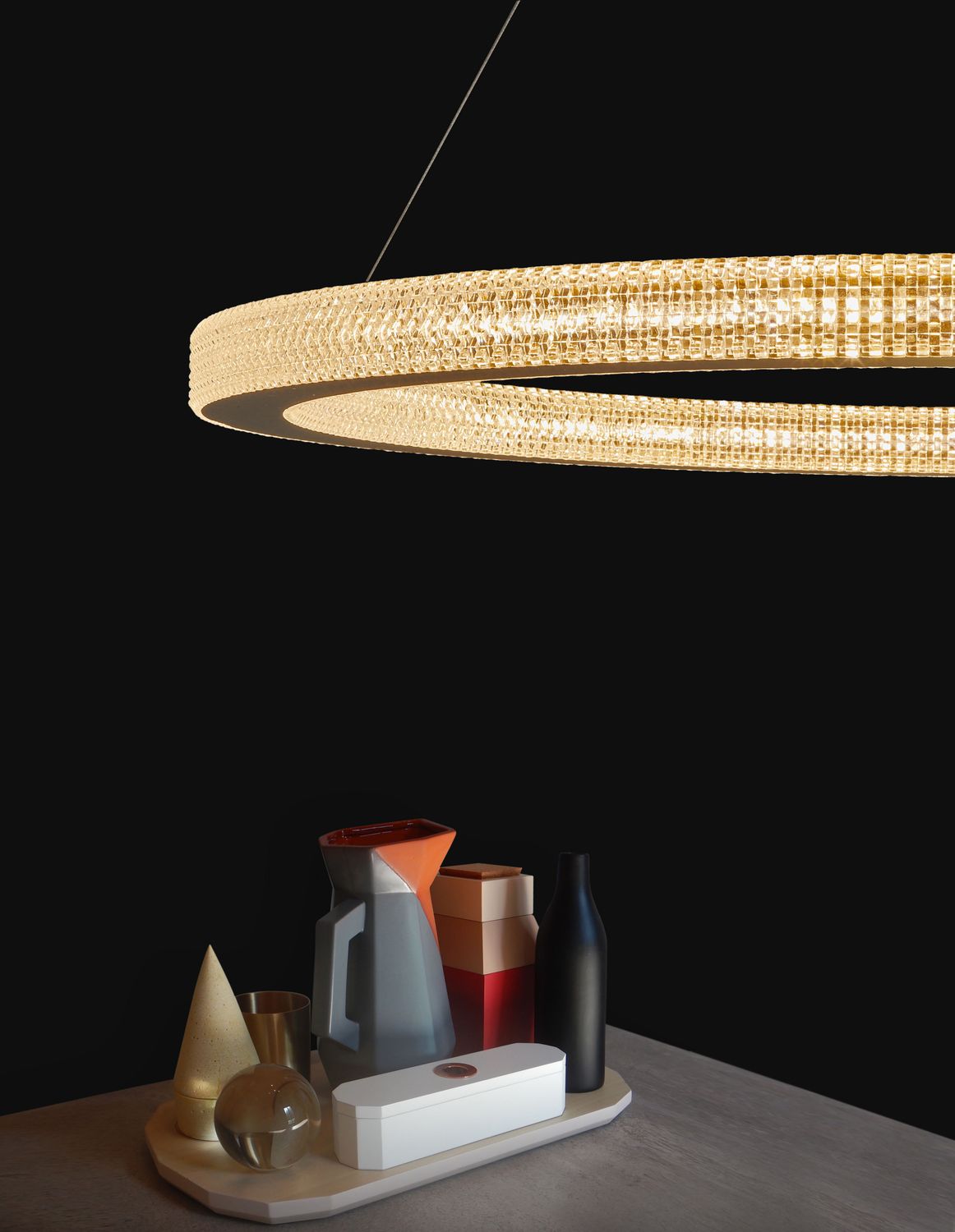 Suspension anneau dorée en ambiance sur table noire avec objets décoratifs