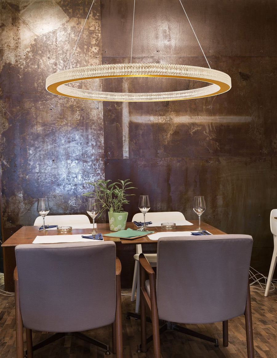 Luminaire annulaire suspendu au-dessus d'une table dressée dans un décor industriel
